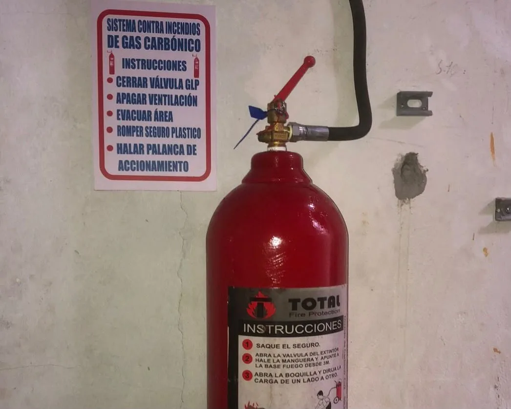 Cilindro CO₂ marca TOTAL con señal de instrucciones